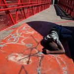 2 October 2018: A boy of around 12-years-old lies passed-out on a pedestrian bridge in Westbury after taking drugs. The Westbury community protested against gang violence and drugs last week. Photograph by James Oatway