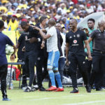 10 November 2018: Pirates assistant coach Rhulani Mokwena is led away after the confrontation with a Sundowns fan during the Absa Premiership match between Mamelodi Sundowns and Orlando Pirates at Loftus Versfeld. (Photo by Phill Magakoe/Gallo Images)